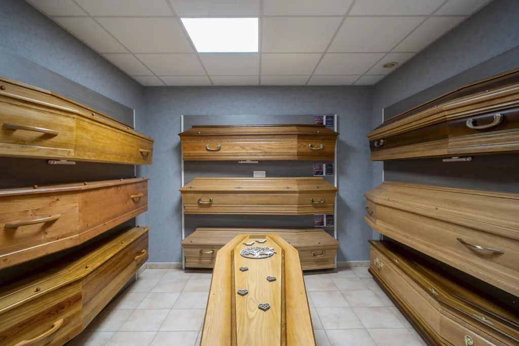 Salle d'exposition présentant une gamme de cercueils en bois massif pour obsèques