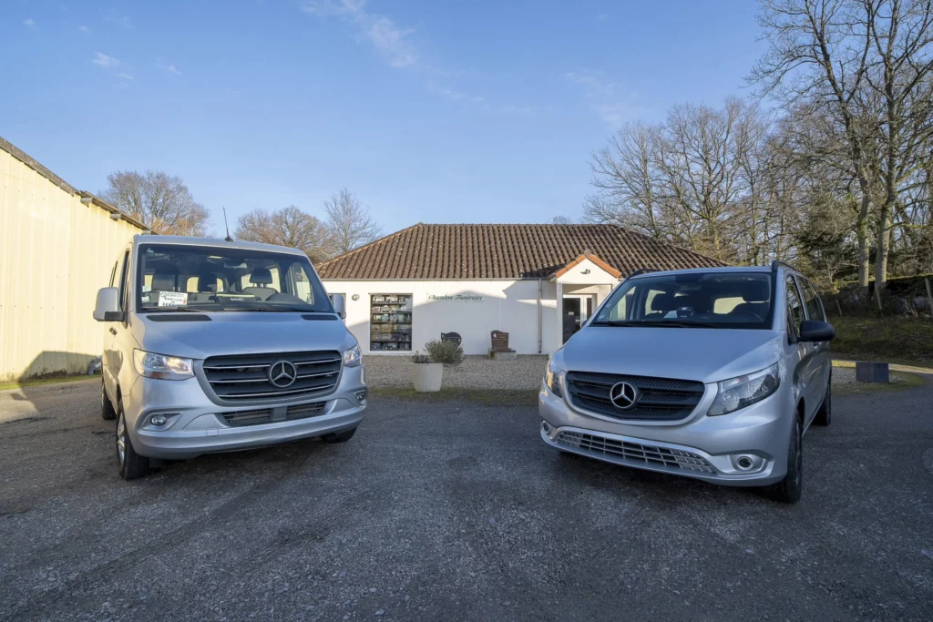Deux véhicules funéraires Mercedes gris stationnés devant le bâtiment d'une chambre funéraire