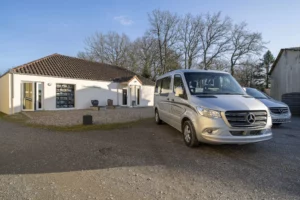 Bâtiment d'une chambre funéraire avec véhicules de transport Mercedes stationnés sur la cour